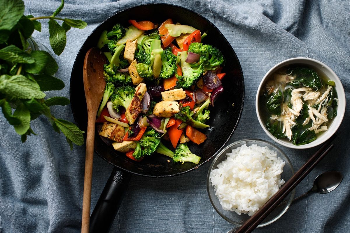 Poêlée de tofu et de légumes servie avec un bol de riz