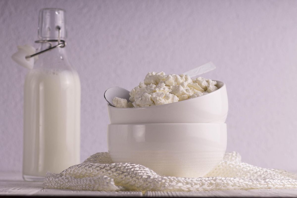 Bouteille de lait et bols de fromage frais en grains